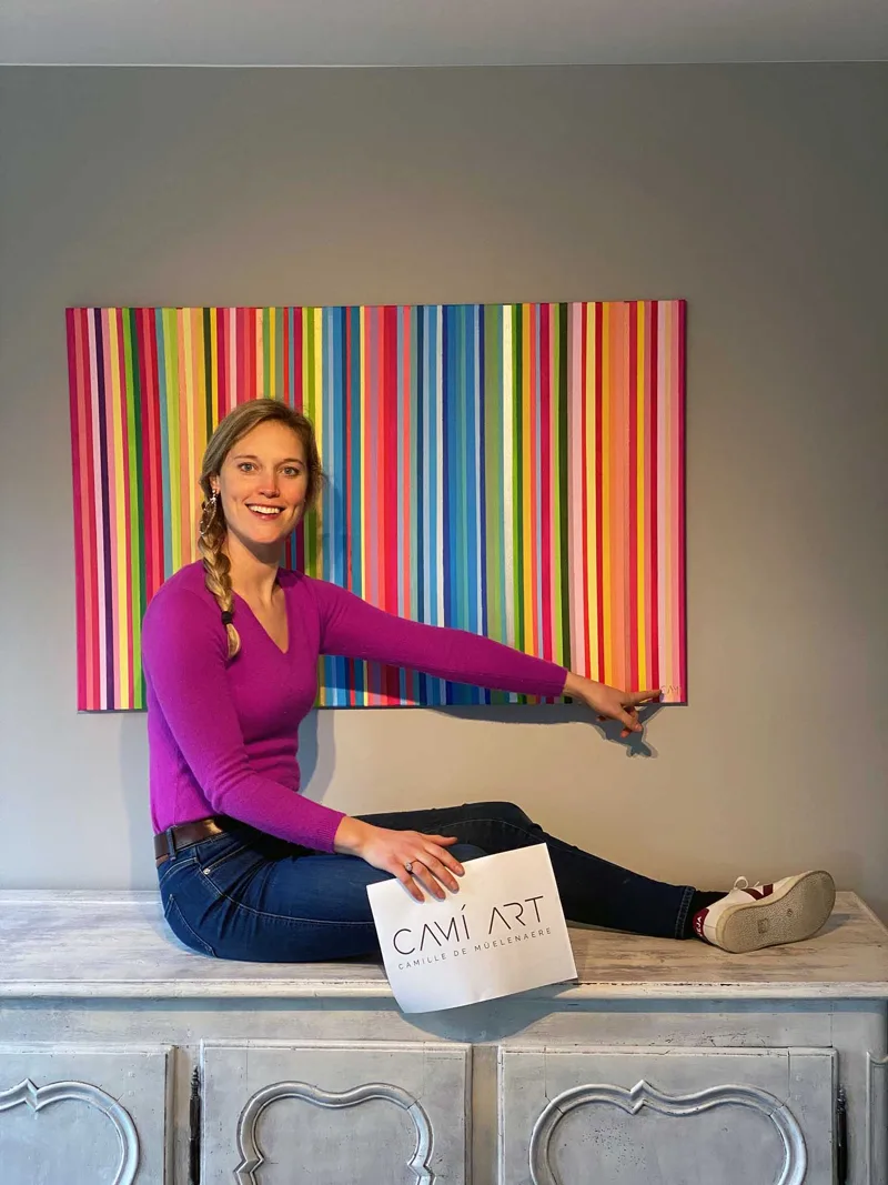 Camille De Mûelenaere in front of one of her striped paintings